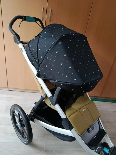 Tmavá stříška se zlatým vzorem na kočárku Thule